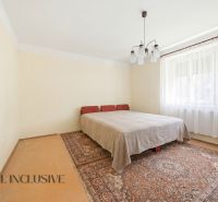 A bedroom in a family house with carpets and curtains.
