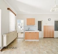 A kitchen in a family house with a wooden decor floor and wooden cabinets.