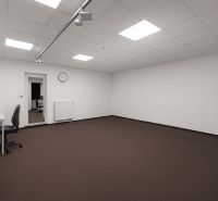 Spacious offices with white walls, brown carpet, and minimalist furnishings.
