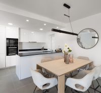 Dining room in a 2-room apartment with a spacious table and kitchen.