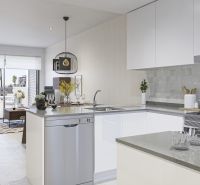 Interior of a holiday apartment with a modern kitchen and a view of the coastline.