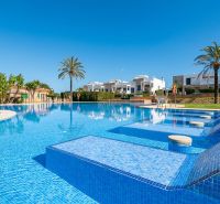 A swimming pool at a holiday apartment in Cala Murada, Mallorca, with palm trees and loungers.