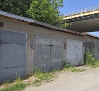 Garages on Jesenského Street in Zvolen along the road with greenery and graffiti.