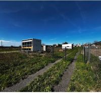 Land - housing in Pernek with containers, fences, and a grassy road in the countryside.