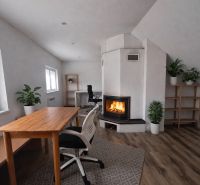 A family house with a fireplace, a wooden table, and a floor with a wooden decor.