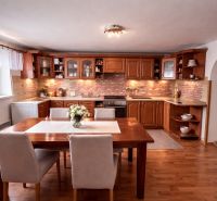 A kitchen in a family house with a dining table and a wooden decor floor.