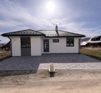 A family house in Ižipovce with parking spaces and a tiled roof under a sunny sky.
