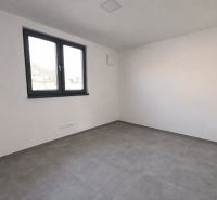Empty room with tiled floor, white walls, and a large window in a family house.