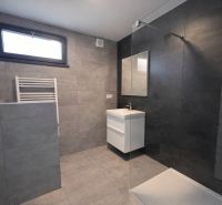 Modern bathroom with ceramic tiles and a large shower in a family house.