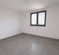 An empty room with a window and tiles in a family house.