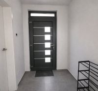 In the interior, we see an entrance door, white walls, and tiles with keys on the floor.