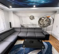 Living room in a one-bedroom apartment with a corner sofa, wooden decor flooring, and a decorative ceiling.