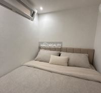 Guest room in a studio apartment with a minimalist design and a comfortable bed.