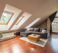 Living room in a three-room apartment with a wooden decor floor and skylights.