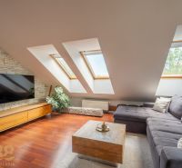 Attic living room in a 3-room apartment with a corner sofa and a wooden decor floor.