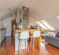 Attic 3-room apartment with a kitchen island, wood-patterned flooring, and skylights.