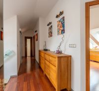 A hallway in a 3-room apartment with dressers and decorations, floor with wood decor.
