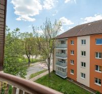 View from the balcony of a 3-room apartment in Poprad to the surrounding greenery and residential building.