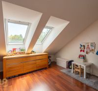 Children's room in a 3-room apartment with slanted windows and a wooden decor floor.