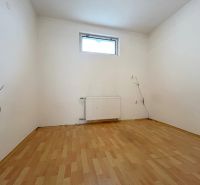 A room in a family house with a wooden decor floor and a radiator under the window.