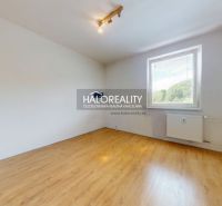 A room in a three-room apartment with a wooden decor floor and a large window.
