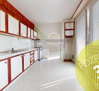 A kitchen in a 3-room apartment with older cabinets and balcony doors.