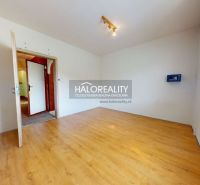 A bright room with a wood-patterned floor in a three-room apartment.