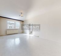 A spacious room with a large window in a 3-room apartment, floor with wooden decor.
