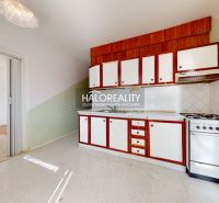 A kitchen with a stove and cabinets in a 3-room apartment, flooring with a floor decor.