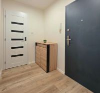 Entrance hallway in a 2-room apartment with wood-patterned flooring and furniture.