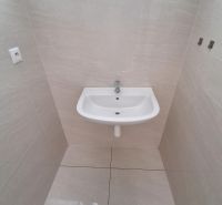 A sink in the office on light tiles with a glossy floor.