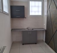 Offices with a kitchenette, tiled flooring, and a gray cabinet, suitable for a work environment.