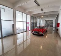 Offices with a red car, floor with wooden decor, glass partitions.