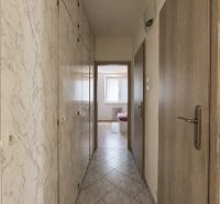 A hallway with built-in wardrobes and tiles leads to a room in a 3-room apartment.
