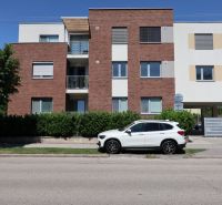 An apartment building on Štefánikova Street in Dunajská Streda with a white car in the foreground.