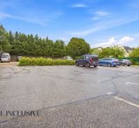 A parking lot in Nitra surrounded by greenery and cars in the Gastro premises.
