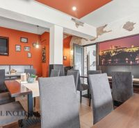 Interior of dining spaces with orange walls and gray chairs, accentuated by decorative elements.