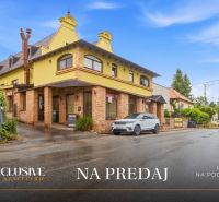 Street with a building, Gastro premises for sale in Nitra, lined with greenery and parking lot.