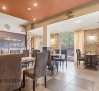 A restaurant space with brick walls and gray chairs, suitable for gastronomy businesses.