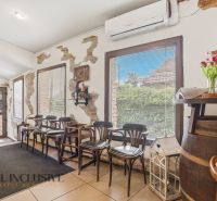 Interior of gastro spaces with bar stools, a decorative gramophone, and flowers on the table.