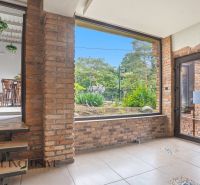 Interior with brick walls and a view of the outside greenery in dining spaces.