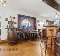 Interior of a gastro space with brick cladding, wooden barrels, and a floor with a wooden decor.