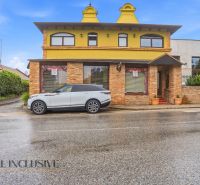 The exterior of dining spaces in Nitra with a car parked in front of the building.