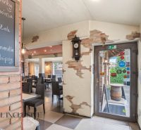 Interior of a gastro space with brick walls and a menu board.