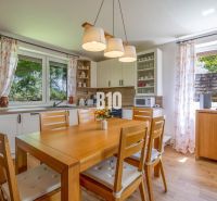 A kitchen in a family house with a wooden table and decor, in light colors.