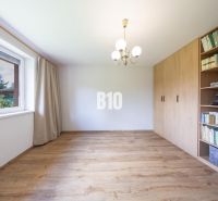 A family house with a wooden decor floor and a built-in bookshelf.