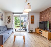 Living room in a family house with a brick wall, comfortable sofa, and wooden decor flooring.
