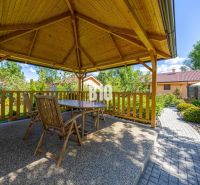 A wooden gazebo with seating in the garden of a family house in Bíková Humence.