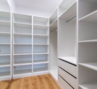 A bright wardrobe with plenty of storage space and a wooden decor floor.