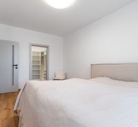 Bright bedroom with a walk-in closet, wood-decor flooring, 3-room apartment.
